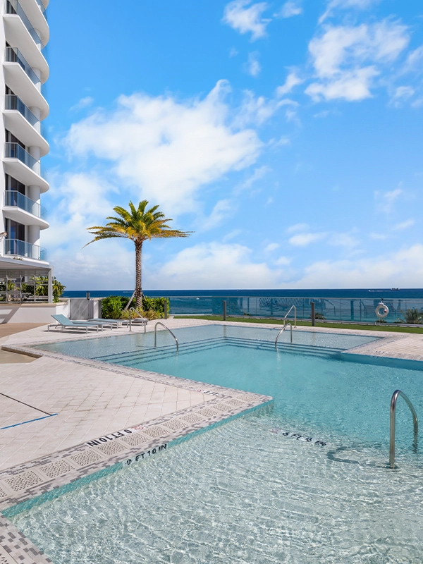 Private beachfront pool beside modern high-rise overlooking the Atlantic Ocean.