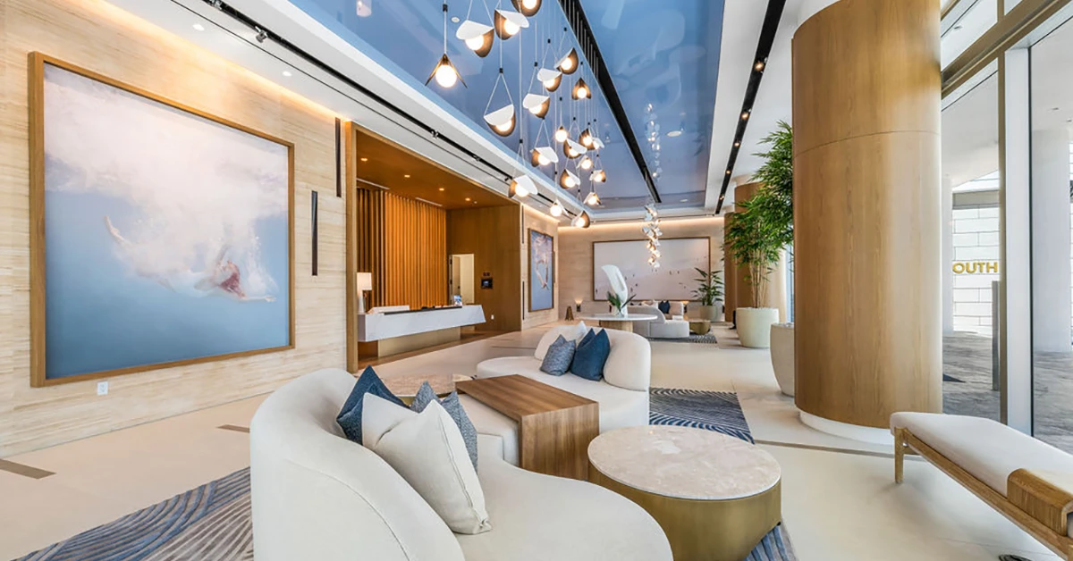 Luxury residential lobby with modern seating, artwork, and designer lighting fixtures.